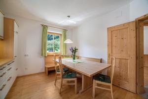 uma sala de jantar com uma mesa de madeira e cadeiras em Ferienhaus Hof am Schloss em Montechiaro