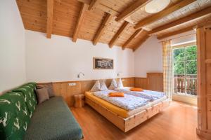 sypialnia z 2 łóżkami, kanapą i oknem w obiekcie Ferienhaus Hof am Schloss w mieście Montechiaro