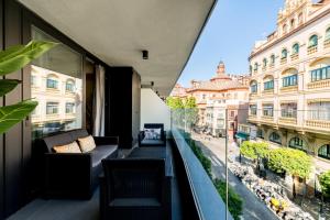 uma varanda com um sofá e vista para a cidade em Apartmentsole - San Pablo em Sevilha