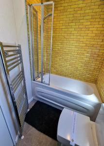 a bathroom with a toilet and a bath tub at View point lodge in Newton on the Moor +32 photos