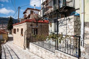 an old house with a balcony on a street at Το Πέτρινο της Γιαγιάς Μαρίκας in Karpenision