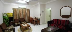 a living room with a red couch and a table at Sweet aqaba apartment in Aqaba