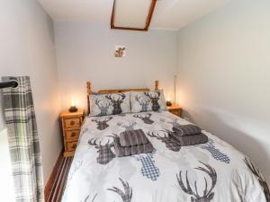 een slaapkamer met een bed met een dekbed bij Lathkill Barn in Bakewell