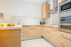 a kitchen with wooden cabinets and a microwave at Inside Barcelona Apartments Salva in Barcelona