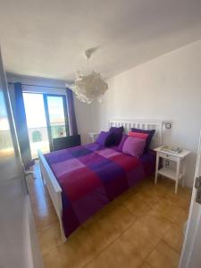 1 dormitorio con 1 cama grande con una manta colorida en Holiday house Parque Azul Playa La Arena FREE WIFI, en Puerto de Santiago