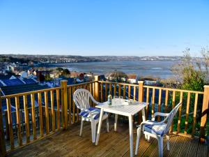 einen Tisch und Stühle auf einer Terrasse mit Blick auf das Wasser in der Unterkunft Pass the Keys Charming Fisherman's cottage with stunning sea views in Swansea