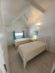 sypialnia z 2 łóżkami w pokoju z sufitem w obiekcie 5 min from Orient Bay - perfect condo, Idolem résidence unité 6 - 57 Rue du Mont Vernon 1 w mieście Cul de Sac