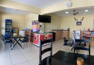 a dining room with tables and chairs and a tv at Pousada Sertaneja in Canindé de São Francisco