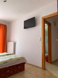 a bedroom with a bed and a flat screen tv on the wall at Abigél Apartmanház in Balatonfüred