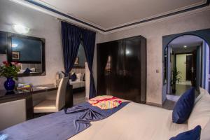 a bedroom with a bed and a desk and a room at Hotel Meriem Marrakech in Marrakech