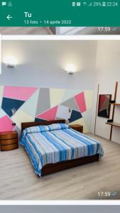 1 dormitorio con 1 cama con una pared colorida en Gemy, en Boissano