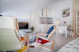 a living room with two chairs and a desk at Sweet Loft Apartment (White) in Rijeka center in Rijeka