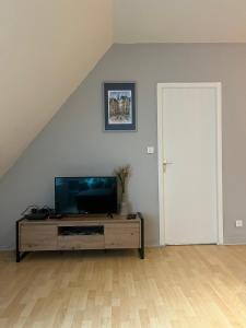 - un salon avec une télévision à écran plat sur une armoire en bois dans l'établissement Sarlat 4 Life, à Sarlat-la-Canéda