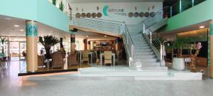 a restaurant with a staircase in a shopping mall at Hotel Neptuno by ON GROUP in Roquetas de Mar