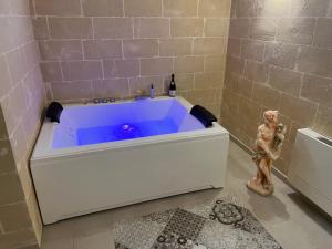 a large blue tub in a bathroom with a statue at Dimora Margherita in Matera