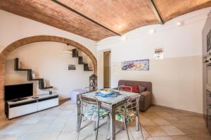 een woonkamer met een tafel en een bank bij Borgo Rosia 85 in Rosia