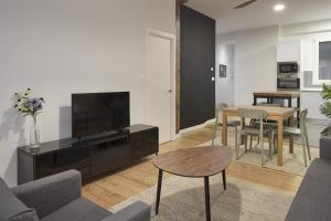 a living room with a television and a table and chairs at Always Easy I Kursaal in San Sebastián