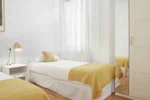 a white bedroom with two beds and a window at Always Easy I Kursaal in San Sebastián