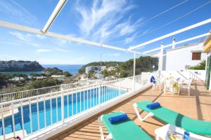 a balcony with chairs and a swimming pool on a house at Collmar by Sonne Villas in Cala Galdana