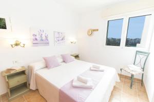 a white room with two beds and a chair at Collmar by Sonne Villas in Cala Galdana +34 photos