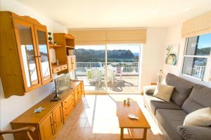 a living room with a couch and a tv and a table at Collmar by Sonne Villas in Cala Galdana