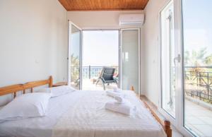 a bedroom with a bed and a large window at Villa Gousetis on the Beach in Zakynthos Town