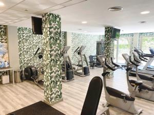 un gimnasio con cintas de correr y elípticas en una habitación en Hotel Neptuno by ON GROUP, en Roquetas de Mar