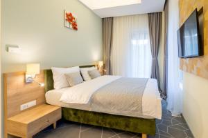 - une chambre avec un grand lit et une télévision dans l'établissement Hotel Console, à Slobozia