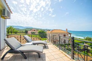 a balcony with chairs and a view of the ocean at Villa Gousetis on the Beach in Zakynthos Town