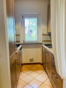 a kitchen with a window and a tiled floor at Villa Claudia a 400m dal mare in Porto Recanati