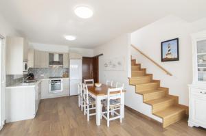 uma cozinha e sala de jantar com uma mesa e uma escada em Casa Febrer by Sonne Villas em Cala Galdana