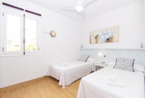 a white room with two beds and a window at Casa Febrer by Sonne Villas in Cala Galdana +30 photos