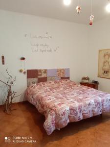 1 dormitorio con cama con colcha rosa. en Sunset Cottage, en Cinisi