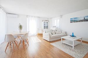 een witte woonkamer met een witte bank en een tafel bij Duplex toit terrasse vue panoramique in Montpellier