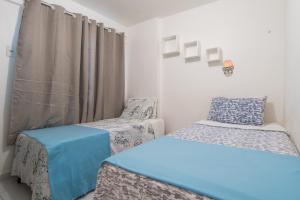 Habitación con 2 camas y cortina en 4let Natal Verano, en Natal