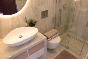 Un baño con lavabo, ducha e inodoro. en Appartamento Fronte Mare Sottomarina, en Sottomarina