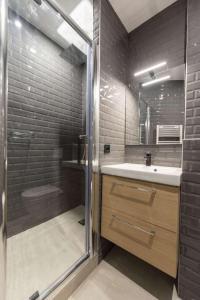 a bathroom with a shower and a sink and a glass shower door at Marianne in Paris