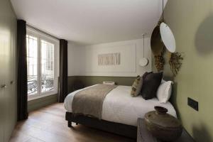 sypialnia z łóżkiem i dużym oknem w obiekcie Marianne w Paryżu