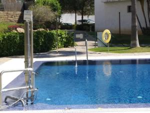 - une piscine d'eau bleue en face d'un bâtiment dans l'établissement Alamar Mijas Sweet Apartament, à Malaga