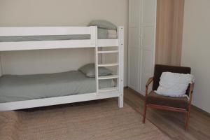 Un dormitorio con dos literas y una silla. en Appartamento Fronte Mare Sottomarina, en Sottomarina