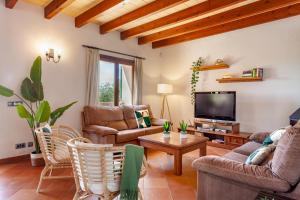 Una sala de estar con muebles y un televisor de pantalla plana. en Bassa Seca by dracmallorca, en Santanyí