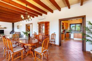 Una cocina y un comedor con mesa y sillas de madera. en Bassa Seca by dracmallorca, en Santanyí