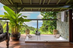 une baignoire sur une terrasse avec vue sur l'océan dans l'établissement TropicAngel ECOLODGE de Charme, à Pointe-Noire