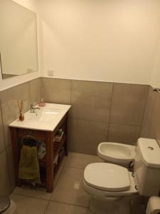 y baño con aseo blanco y lavamanos. en Casa Perez en San Martín de los Andes