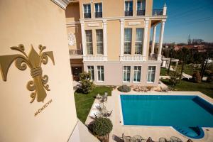 a large house with a swimming pool in front of it at Hotel Tresor Le Palais in Timişoara