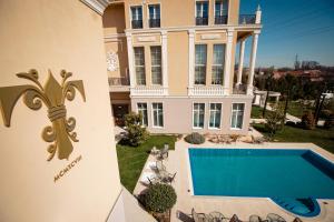 una grande casa con una piscina di fronte di Hotel Tresor Le Palais a Timişoara