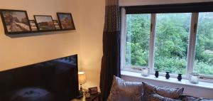 een woonkamer met een televisie en een raam bij The Roman Retreat in Chester