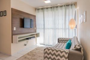 a living room with a couch and a television at MonteSanto Verano in Natal