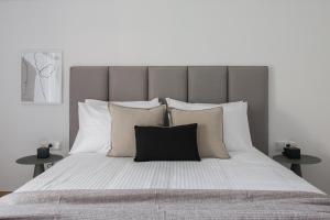 a bedroom with a large bed with white sheets and pillows at Stellar 3BR Apartment with Balcony by UPSTREET in Athens