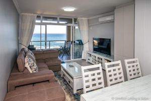 a living room with a couch and a tv at Twin Tide Duplex in Umdloti